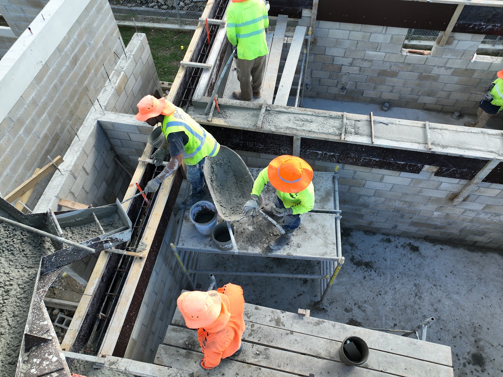 Construction workers completing reinforced concrete and formwork installation on an active structural building project.