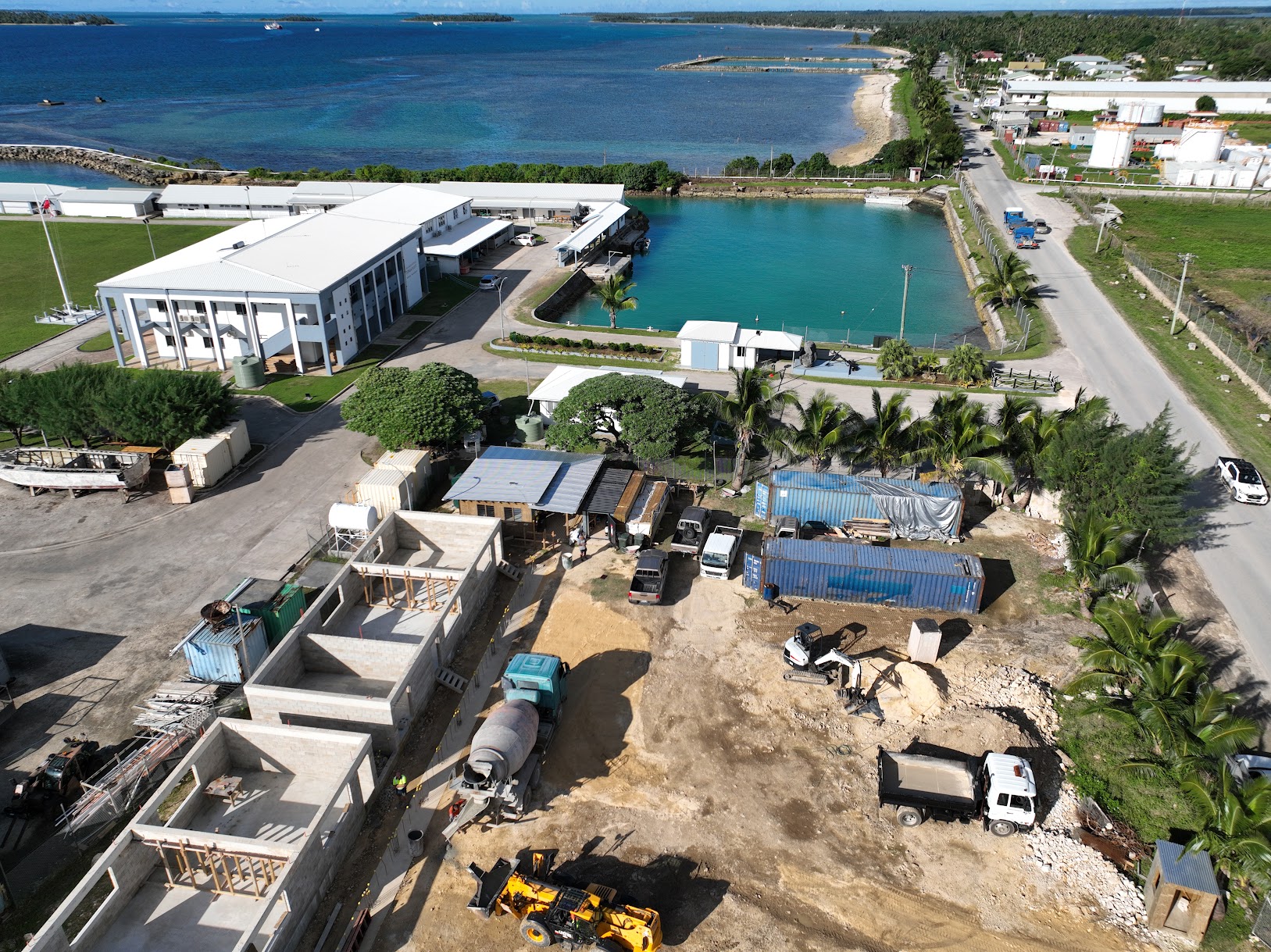 Aerial drone view of a coastal commercial construction project by Build N Concrete Ltd featuring active building works and waterfront surroundings.